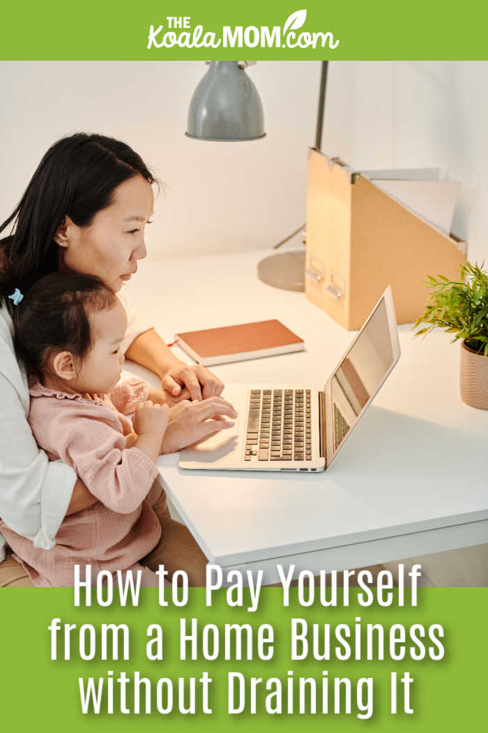 How to Pay Yourself from a Home Business without Draining It. Photo of Asian mom holding baby on her lap while working on a laptop by ShotPot via Pexels.
