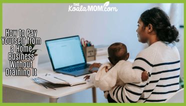 How to Pay Yourself from a Home Business Without Draining It. Photo of mom holding a baby on her arm while doing work / bookkeeping at a laptop by William Fortunato via Pexels.